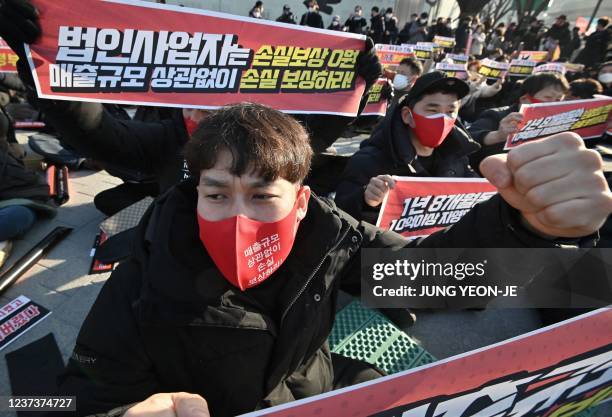 South Korean small business owners shout slogans during a rally against the government's policy on vaccine passes and business restrictions related...