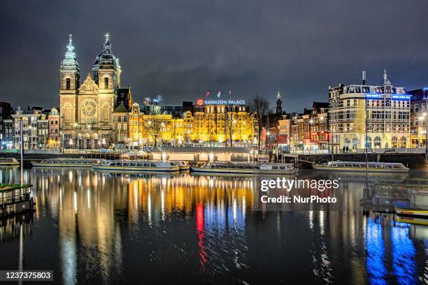 Night view of the canals with boats and buildings with their reflection on the water of the canals. Streets of Amsterdam during the first day of the...