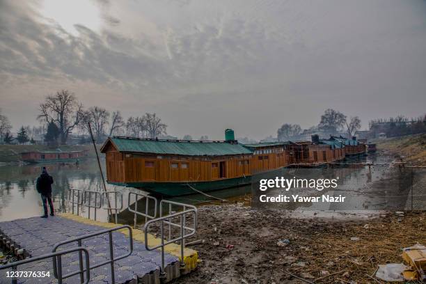 Houses boats are moored to the bank of river Jehlum, on December 22, 2021 in Srinagar, the summer capital of Indian administered Kashmir, India. The...