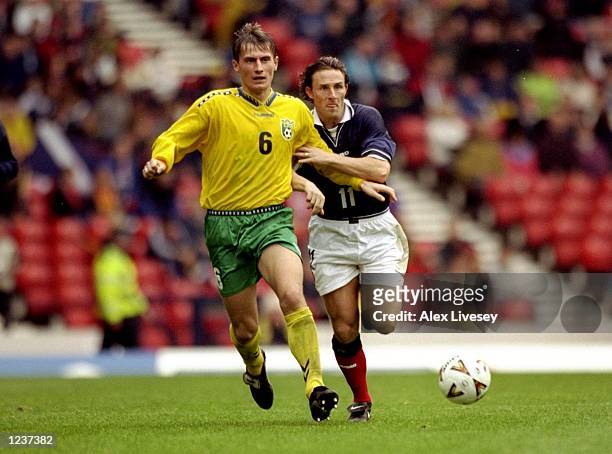 Tomas Zvirgzdauskas of Lithuania holds off Gary McSwegan of Scotland during the European Championships Group 9 qualifier against Lithuania at Hampden...