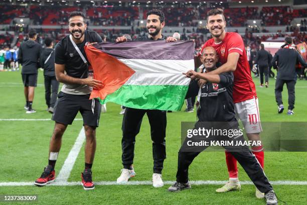 Ahly's players wave a Palestinian national flag after winning the CAF Super Cup football match between Egypt's Al-Ahly and Morocco's Raja Club...