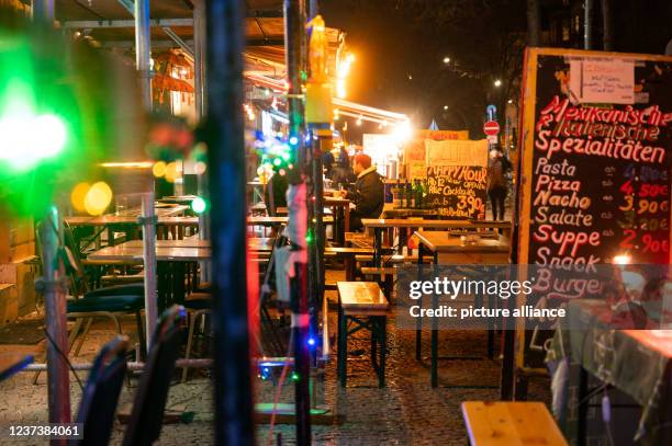 December 2021, Berlin: Restaurants on Simon-Dach-Strasse in Friedrichshain are illuminated. Photo: Christophe Gateau/dpa