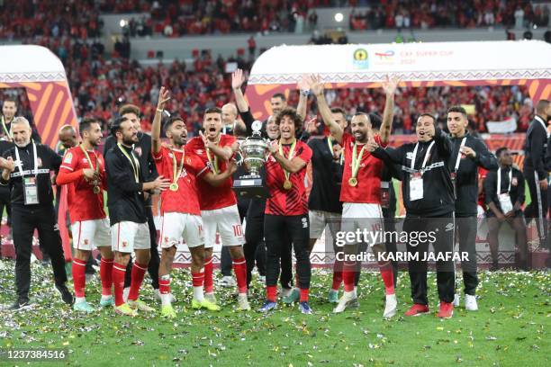 Ahly's players celebrate with the winners trophy following the CAF Super Cup football match between Egypt's Al-Ahly and Morocco's Raja Club Athletic...