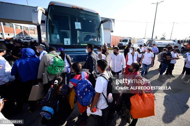 Migrants heading in a caravan towards the US board a bus at the "House of the Pilgrim San Juan Diego" in Mexico City, on December 22, 2021. - Central...