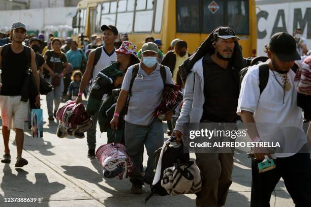 Migrants heading in a caravan towards the US wait for buses at the "House of the Pilgrim San Juan Diego" in Mexico City, on December 22, 2021. -...