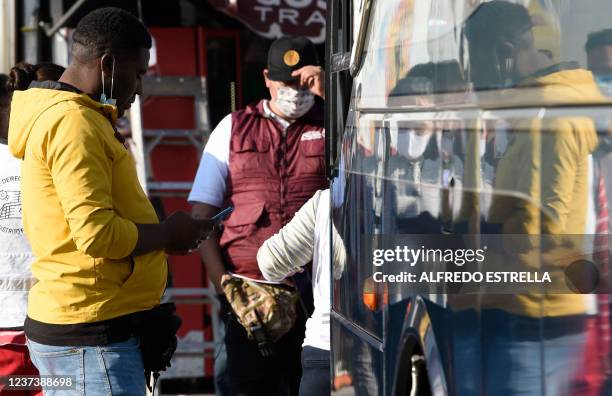 Migrants heading in a caravan towards the US wait for buses at the "House of the Pilgrim San Juan Diego" in Mexico City, on December 22, 2021. -...