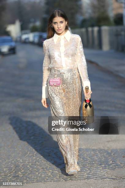 Cathy Hummels wearing a white transparent blouse by Zara , a golden glitter trousers by Zara, a micro bag by Valentino and silber shoes by Boss...