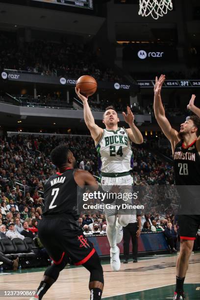 Pat Connaughton of the Milwaukee Bucks shoots against David Nwaba and Alperen Sengun of the Houston Rockets during the NBA game at Fiserv Forum on...