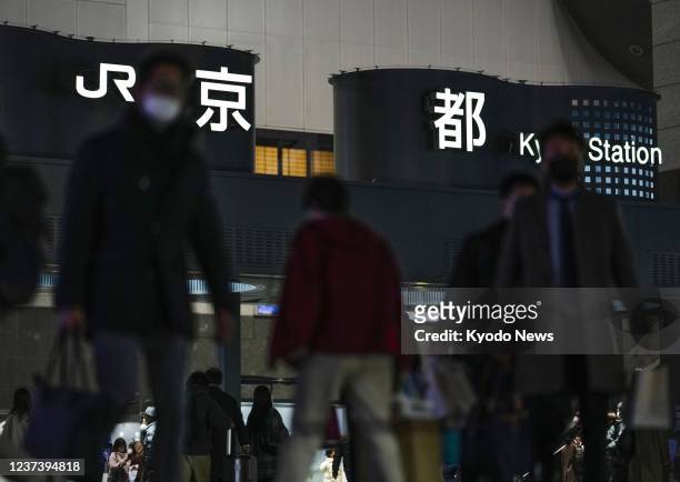 People wearing masks for protection against the coronavirus walk in front of JR Kyoto Station on Dec. 23, 2021. Kyoto Prefecture reported its first...