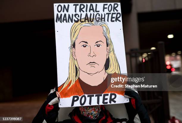 Person holds a sign as they demonstrate outside the Hennepin County Government Center on December 23, 2021 in Minneapolis, Minnesota. Jury...