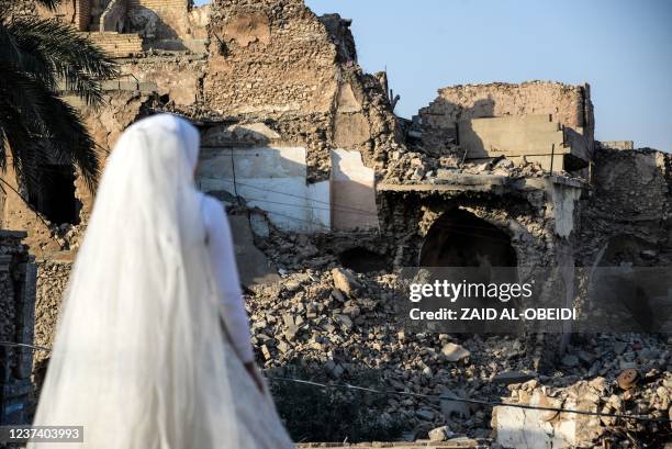 An actress dressed as a bride, stands amid the rubble of buildings, as film students work on a scene, in the war-ravaged northern Iraqi city of...