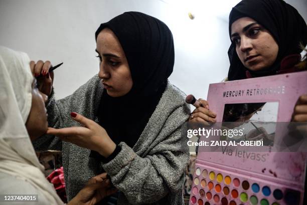 Makeup artists of a film school, prepare an actress dressed as a bride, before shooting a scene in the war-ravaged northern Iraqi city of Mosul, on...