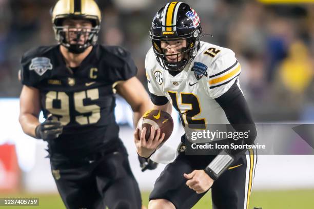 Missouri Tigers quarterback Brady Cook scrambles past defenders during the Lockheed Martin Armed Forces Bowl game between the Army Black Knights and...