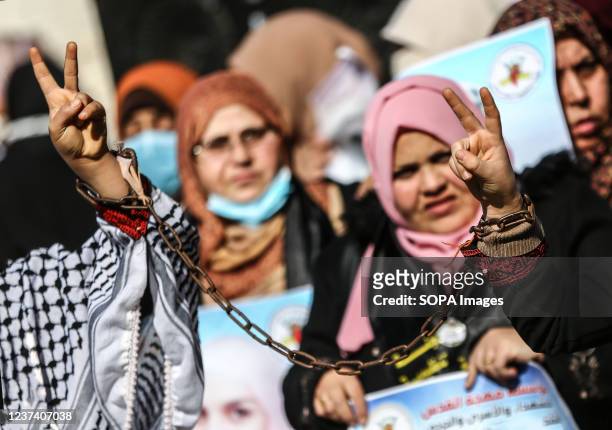 Palestinian woman holds a placard expressing her opinion, during a demonstration of solidarity with Palestinian prisoners inside Israeli prisons, in...