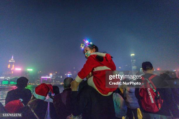 Little girl in Christmas costume waits to watch the &quot;symphony of lights&quot; light show on the Avenue of Stars.