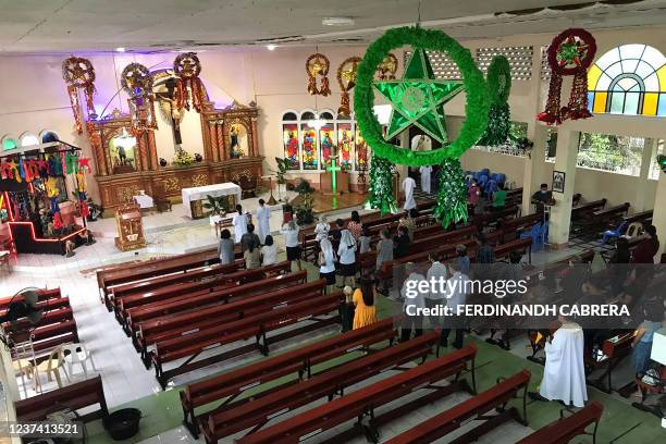 Catholic faithful attend Christmas mass in their destroyed church in Alegria, Surigao del Norte province on December 25 more than a week after Super...