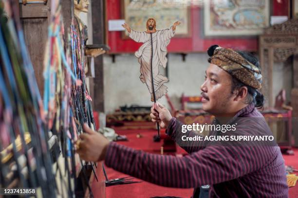 This photo taken on December 24, 2021 shows puppet master Indra Suroinggeno playing Christmas-themed puppetry in Bantul, Yogyakarta. - A small...