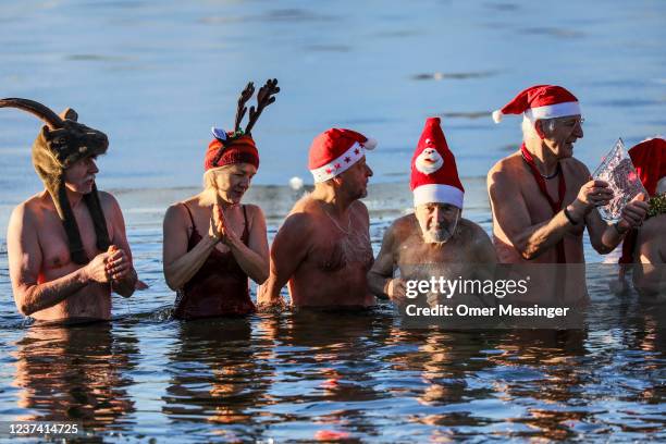 Members of the Berliner Seehunde ice swimming club go for a festive dip on Christmas Day at Orankesee lake on December 25, 2021 in Berlin, Germany....