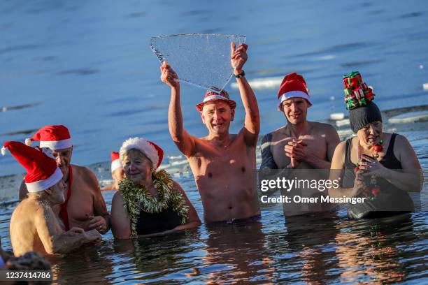 Members of the Berliner Seehunde ice swimming club go for a festive dip on Christmas Day at Orankesee lake on December 25, 2021 in Berlin, Germany....