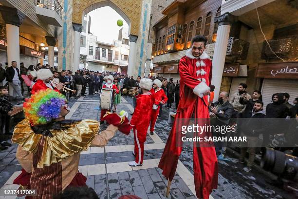 Clowns and musicians perform during the reopening of the renovated al-Mutanabbi street, the historic heart of the book trade and an outlet for...