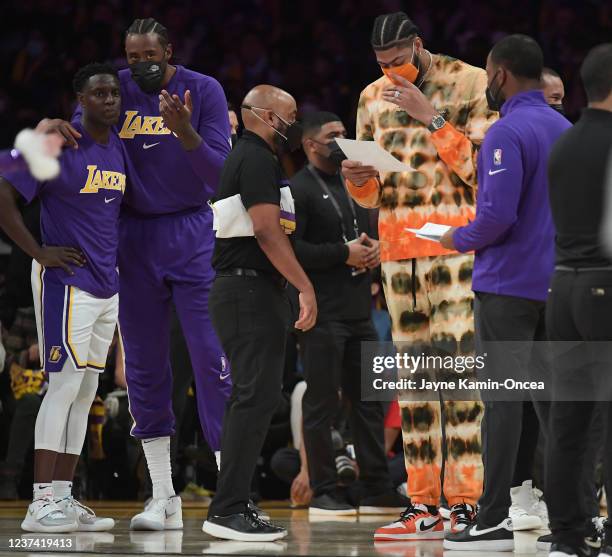 DeAndre Jordan and Darren Collison of the Los Angeles Lakers talk as Anthony Davis reads notes during a time out in the second half of the game...