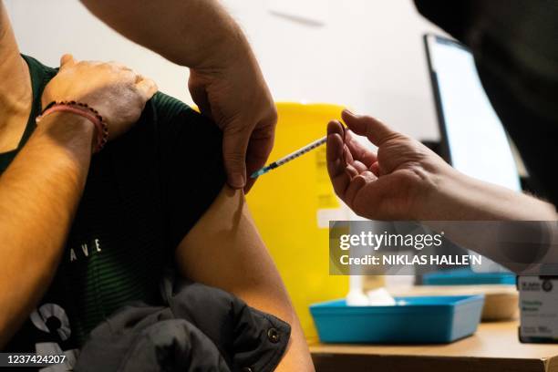 Member of the public receives a dose of a Covid-19 vaccine inside a vaccination centre set up at Grim's Dyke Golf Club in north west London on...