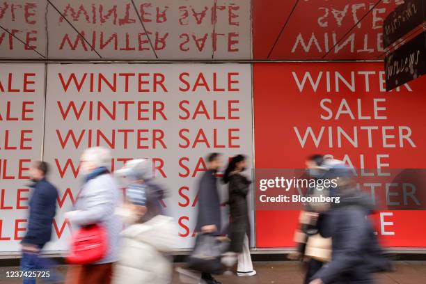 Shoppers pass a winter sale promotion, during the traditional Boxing Day holiday sales, in London, U.K., on Sunday, Dec. 26, 2021. Consumer...