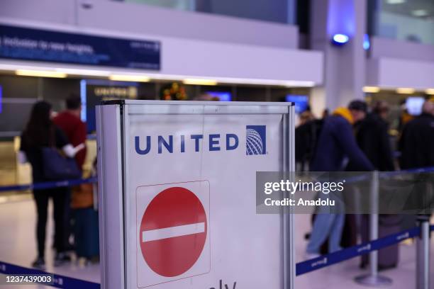 People are seen by the United Airlines counter at the Newark International Airport in New Jersey, United States on December 27, 2021. At least 2,500...