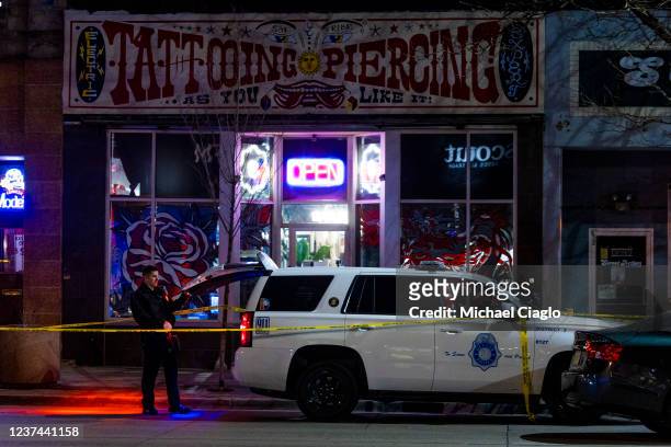 Police officers stand outside Sol Tribe tattoo shop on Broadway where two women were killed and a man was injured in a shooting on December 27, 2021...