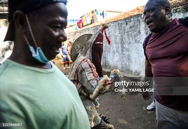 An Ireme , a masked dancer of the men's religious secret society known as Abakua , dances during the oath ceremony of the Efi Barondi Cama "potency"...