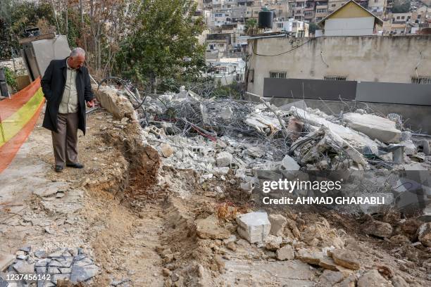 Palestinian man inpects the rubble of a house demolished by Jerusalem municipality workers, which Israeli authorities say was built without a permit,...