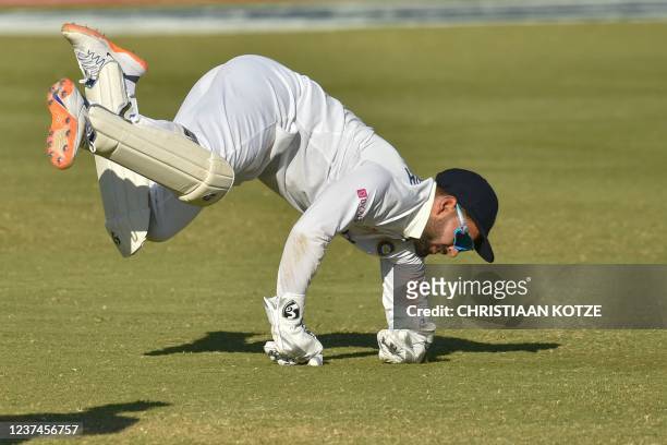 India's Rishabh Pant dives to catch the ball while fielding during the fourth day of the first Test cricket match between South Africa and India at...