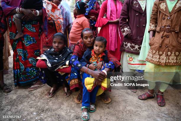 Woman and her kids enjoy watching the traditional group dance at a wedding in Rajshahi. Santal tribe is an ethnic group native to eastern India....