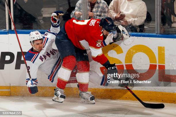 Radko Gudas of the Florida Panthers checks Filip Chytil of the New York Ranges into the boards during first period action at the FLA Live Arena on...