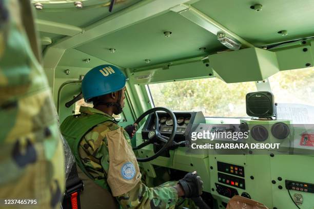 An United Nations peacekeeper drives an armoured personnel carrier during the patrol on a supposedly safe road, avoiding roads with possible...