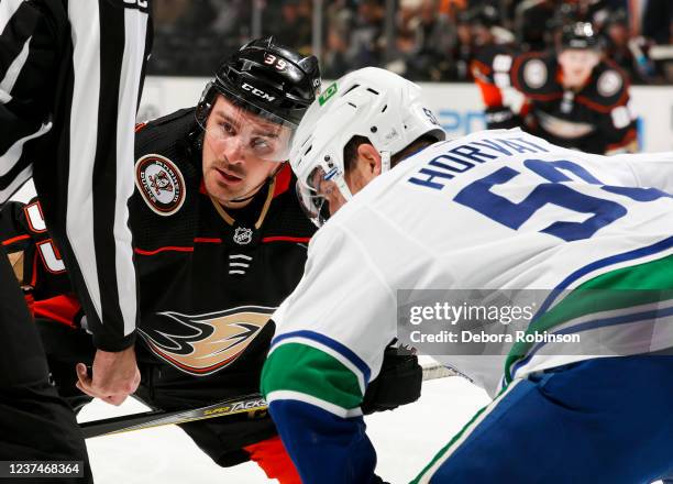 Sam Carrick of the Anaheim Ducks and Bo Horvat of the Vancouver Canucks get ready for the puck drop during the first period at Honda Center on...