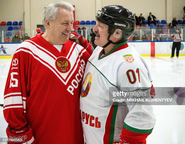 Belarus' President Alexander Lukashenko talks to Soviet hochey star Alexander Yakushev during a hockey match between Russia and Soviet hockey...
