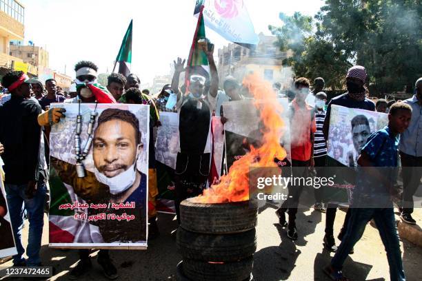 Sudanese demonstrators carry posters of killed protesters as they protest in the capital Khartoum against the army's October 25 coup, on December 30,...