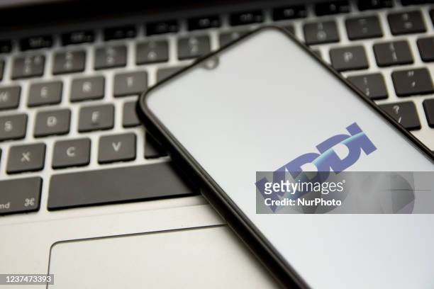 In this photo illustration a KDDI logo seen displayed on a smartphone screen with a computer keyword in the background in Athens, Greece on December...