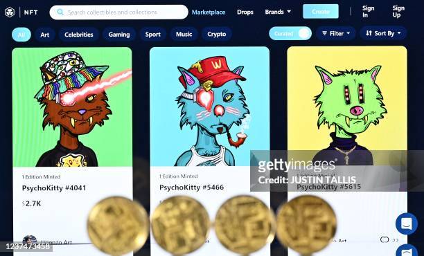 An illustration picture taken in London on December 30 shows gold plated souvenir cryptocurrency coins arranged beside a screen displaying a...