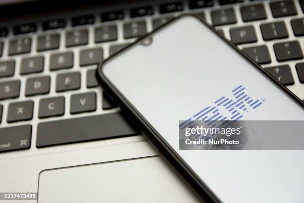 In this photo illustration an IBM logo seen displayed on a smartphone screen with a computer keyword in the background in Athens, Greece on December...