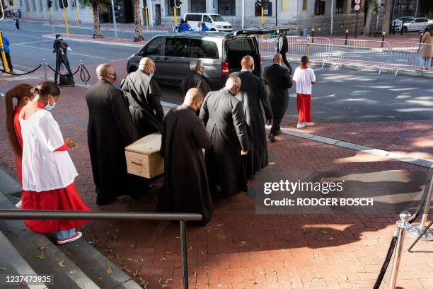 Anglican clerics and alter boys and girls carry the coffin with the remains of South African anti-Apartheid icon, Archbishop Desmond Tutu, out of St....