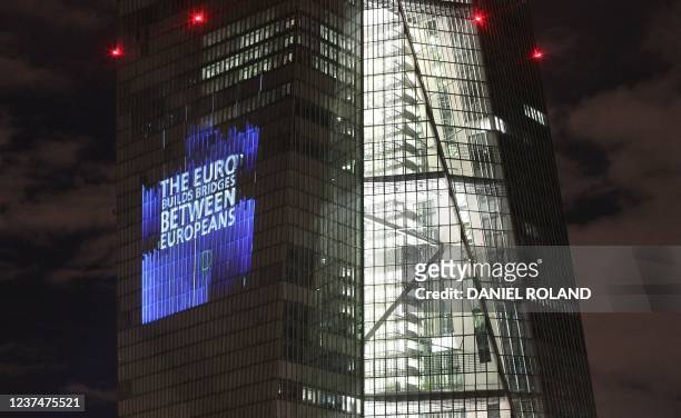 The tower of the European Central Bank main building is pictured by night as the illuminated sign reads "The euro: 343 millions people, 19 states and...