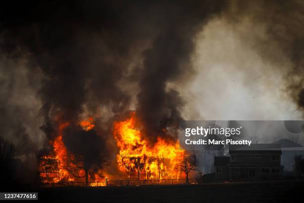 Two homes burn during a wildfire in the Centennial Heights neighborhood on December 30, 2021 in Louisville, Colorado. State officials estimated some...