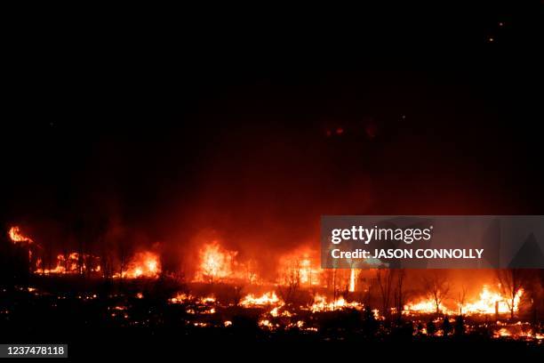 Flames engulf homes as the Marshall Fire spreads through a neighborhood in the town of Superior in Boulder County, Colorado on December 30, 2021. -...