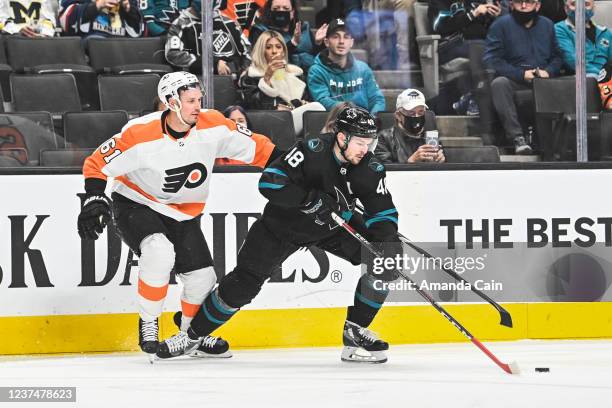 Tomas Hertl of the San Jose Sharks skates with the puck against Justin Braun of the Philadelphia Flyers in a regular season game at SAP Center on...