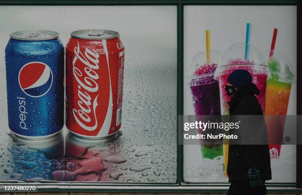 Man walks past a Pepsi and Coca-Cola ad in the center of Edmonton. On Thursday, December 30 in Edmonton, Alberta, Canada.