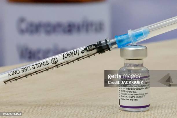 This pictured shows a syringe and vial of the Pfizer-BioNTech vaccine against the coronavirus, at the outpatient clinics of the cardiovascular centre...