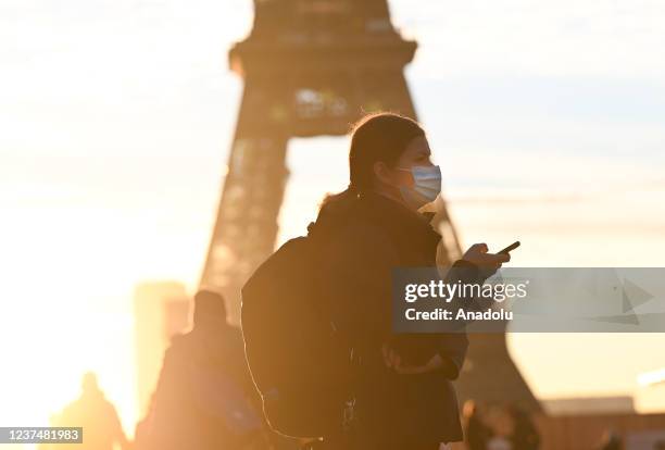 Masked people walk on the Trocadero square near the Eiffel Tower in Paris, France on December 31, 2021