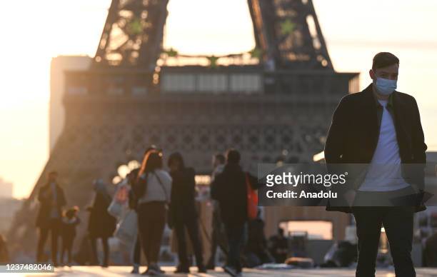 Masked people walk on the Trocadero square near the Eiffel Tower in Paris, France on December 31, 2021